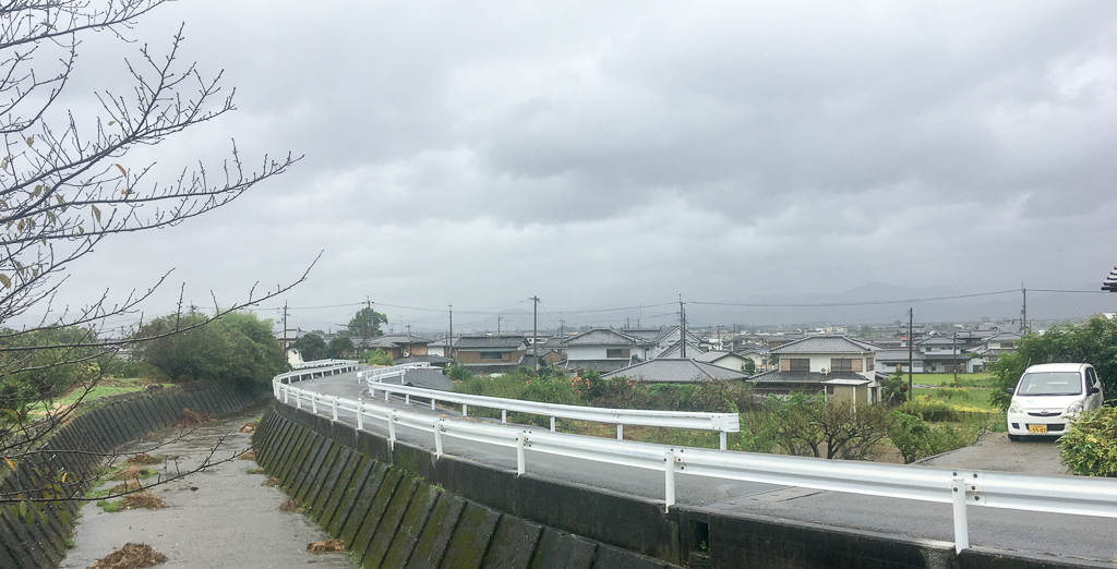 Een vliegende storm trekt over Japan, donkere wolken boven de weg